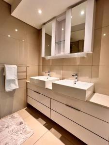 a bathroom with two sinks and a mirror at iTowers luxurious 1-Bedroom apartment- 15th Floor in Gaborone