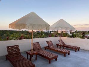 a group of chairs and umbrellas on a balcony at La Veleta luxury condos in Tulum