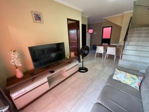 a living room with a flat screen tv and a couch at Casa Lua Cheia na Praia de Peroba, Maragogi in Maragogi