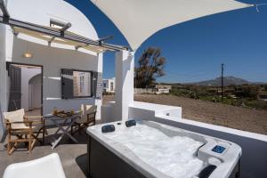 a bathroom with a bath tub on a patio at Red Beach Harmony suites Sotiria in Akrotiri