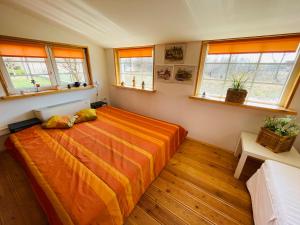 1 dormitorio con 1 cama grande en una habitación con ventanas en Botanica Deluxe Vendégház - Finnish Sauna en Siófok
