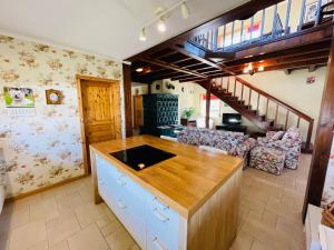 a kitchen with a counter and a living room at Botanica Deluxe Vendégház - Finnish Sauna in Siófok