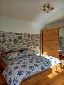 a bedroom with a stone wall and a bed with pillows at Landhaus Grünjuwel in Himmelberg