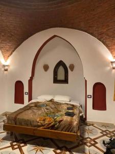 a bedroom with a bed in an arched room at Leyla Eco Resort Queen Suites in Luxor