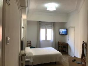 a bedroom with a bed and a television at Hostal La Mexicana in Santander