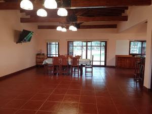 ein Wohnzimmer mit einem Tisch, Stühlen und einem TV in der Unterkunft Cabañas Cafayate III in Cafayate