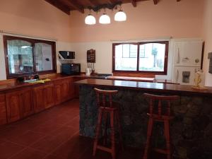 eine Küche mit einer Theke und 2 Hockern an einer Bar in der Unterkunft Cabañas Cafayate III in Cafayate