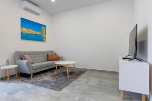 sala de estar con sofá, TV y mesas en Perfect Location, Idyllic 2BR Apartment, en Sliema