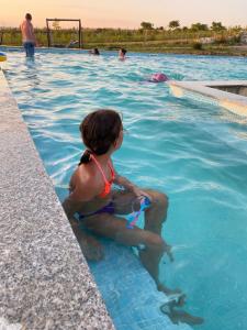młoda dziewczyna siedząca w basenie w obiekcie Complex Turistic Dávid w mieście Boghiş