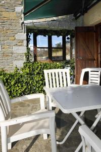 two white chairs and a white table and chairs at Chardín Bellvedé-Apartamentos Chardins in Cerler