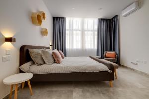 ein Schlafzimmer mit einem Bett und einem Stuhl in der Unterkunft Perfect Location, Modern 2BR Apartment in Sliema