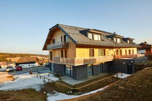 a house with a metal roof on top of it at Kvilda Apartments in Kvilda +5 photos