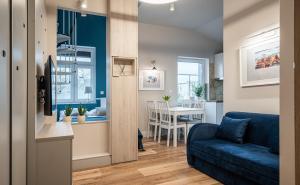 a living room with a blue couch and a table at Apartamenty ZOFIJÓWKA in Toruń