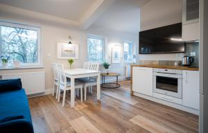 a kitchen and dining room with a table and chairs at Apartamenty ZOFIJÓWKA in Toruń +18 photos