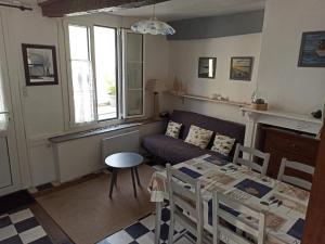 a living room with a table and a couch at L'Estacade : maison de pecheur in Saint-Valéry-sur-Somme