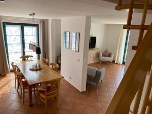 een eetkamer en een woonkamer met een tafel en stoelen bij Ferienhaus Igel in Burg