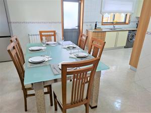 a dining room with a blue table and chairs at Villa Florence in Mogege