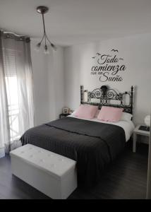 グラナダにあるApartamentos Granada Sierraのベッドルーム1室(壁に看板付)