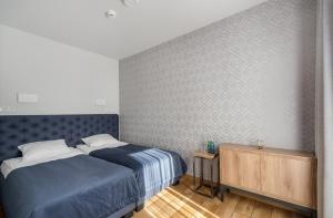 a bedroom with a blue bed and a wall at Apartament Mechelinki in Mechelinki