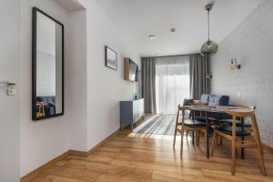 a dining room and living room with a table and chairs at Apartament Mechelinki in Mechelinki