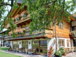 Casa con balcón con sillas y flores en Gästehaus Hirschbichler - Chiemgau Karte, en Inzell