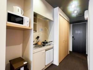 a small kitchen with a microwave and a sink at Hotel S-Presso Central - Vacation STAY 9444 in Osaka