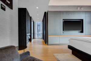 a bedroom with a bed and a tv on a wall at Equinox Hotel Hudson Yards New York City in New York