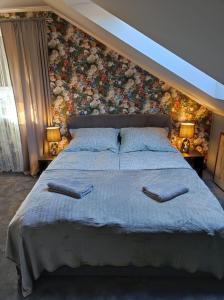 Agroturystyka Klimat في Bircza: غرفة نوم بسرير كبير وبجدار ورد