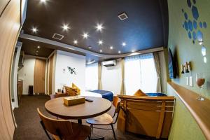 a room with a table and a bed and a table and chairs at Hotel S-Presso Central - Vacation STAY 9451 in Osaka