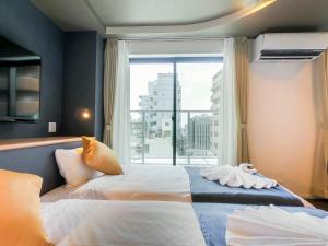 a hotel room with two beds and a window at Hotel S-Presso Central - Vacation STAY 9451 in Osaka