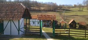 a playground in front of a house with a fence at Apartman Bosanska Avlija-Muzej- in Visoko