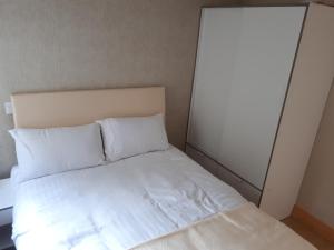 a bed with white sheets and pillows in a room at One double bedroom flat in Dublin