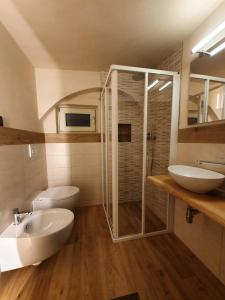 ein Badezimmer mit zwei Waschbecken, einer Dusche und einem WC in der Unterkunft Casa De Giorgis in Aosta