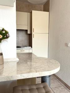 a kitchen with a marble counter top and white cabinets at Coquet appartement avec terrasse sur la mer in Roquebrune-Cap-Martin