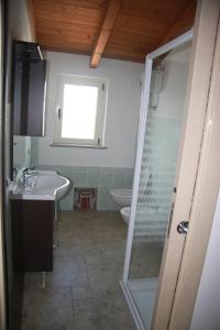 een badkamer met een douche, een wastafel en een toilet bij Panta House in San Giovanni Suèrgiu
