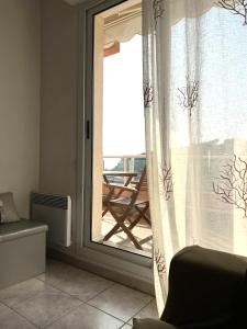 a room with a window with a view of a patio at Coquet appartement avec terrasse sur la mer in Roquebrune-Cap-Martin