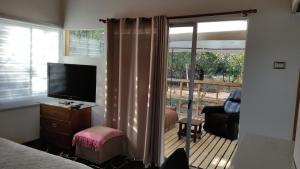 a bedroom with a bed and a television and a balcony at EkoClub in Paine