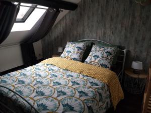 1 dormitorio con cama con edredón y ventana en Cosy Lodg, en Bourogne