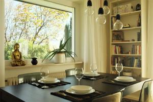 a dining room with a table with glasses and a window at La Vista - Apartment mit Traumblick & Garten in Marlengo +37 photos
