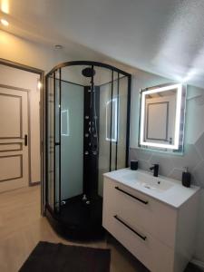 a bathroom with a shower and a sink and a mirror at LA MACHINE Sous Combles in La Machine