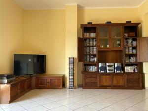 a living room with a flat screen tv and a entertainment center at Pipa’s SunTrap in Taormina