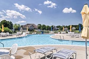 欧申维尤Ocean View Resort Condo with Pool Access and Bay Views的一个带白色椅子、桌子和遮阳伞的游泳池