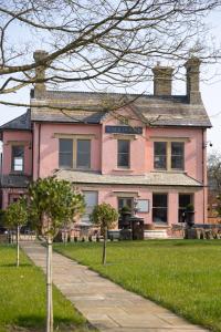 a pink house with trees in front of it at Vale House in Belvoir