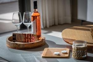 Una botella de vino y dos copas en una mesa. en Sunset - Achziv Beach Apartment - סנסט חוף אכזיב en Nahariyya