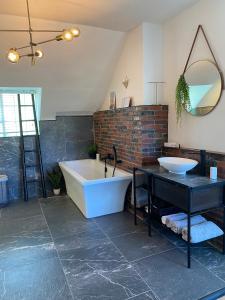 une salle de bain avec une baignoire, un lavabo et un miroir dans l'établissement Cosy and Unique Family Retreat in Hout Bay, au Cap