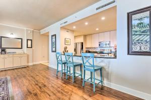 a kitchen with blue bar stools and a counter at Spacious Biloxi Getaway with Pools and Beach Access! in Biloxi