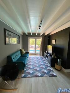 un salon avec un canapé bleu et une télévision dans l'établissement Cosy and Unique Family Retreat in Hout Bay, au Cap 40 autres photos