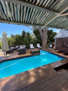 une piscine sur une terrasse en bois avec une pergola dans l'établissement Cosy and Unique Family Retreat in Hout Bay, au Cap