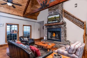 a living room with a stone fireplace and couches at Heaven's Peak in Banner Elk