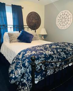 1 dormitorio con 1 cama con manta azul y blanca en Ma Margarets House Bed and Breakfast, en Heathsville
